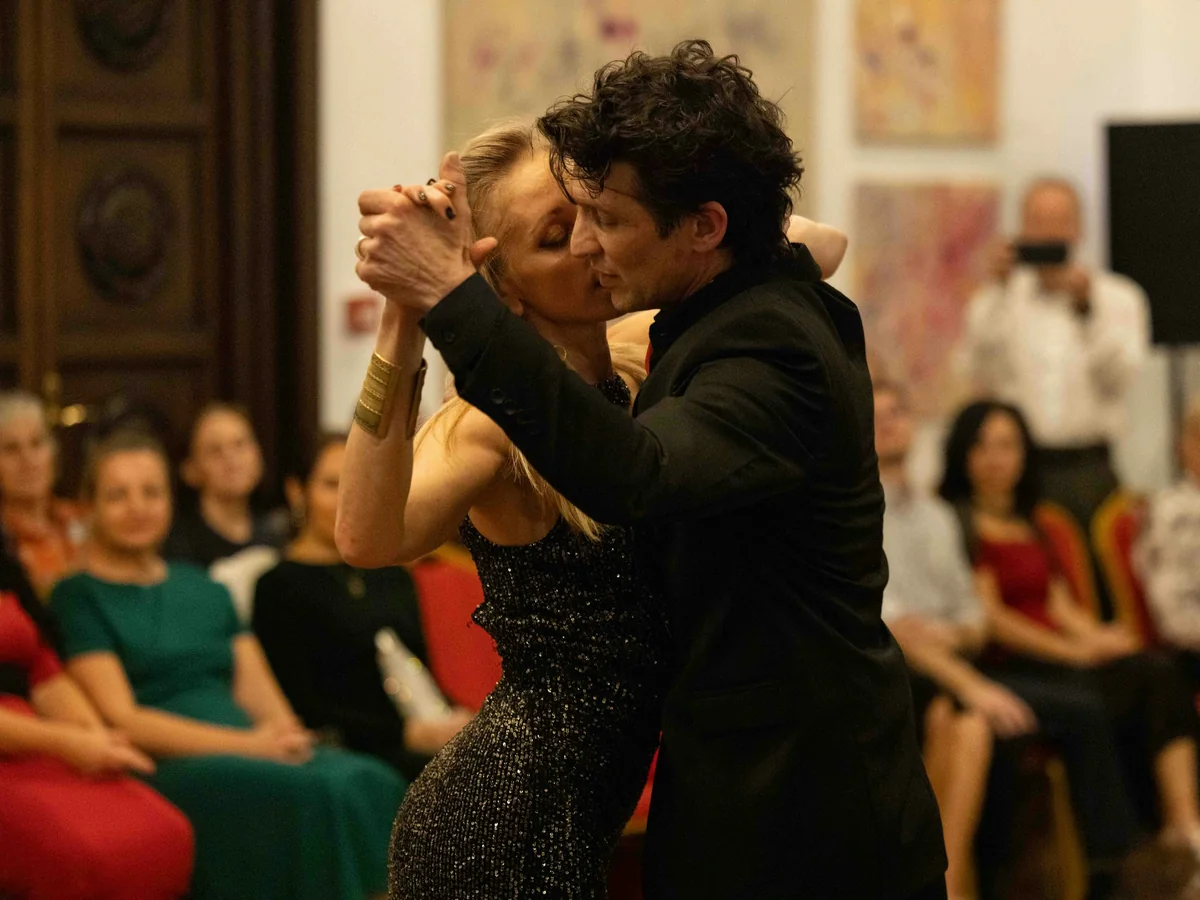 A tango couple dance beside candlelit dinner tables in a theatre setting (representative photograph of a dinner-show performance, not this show's own company)
